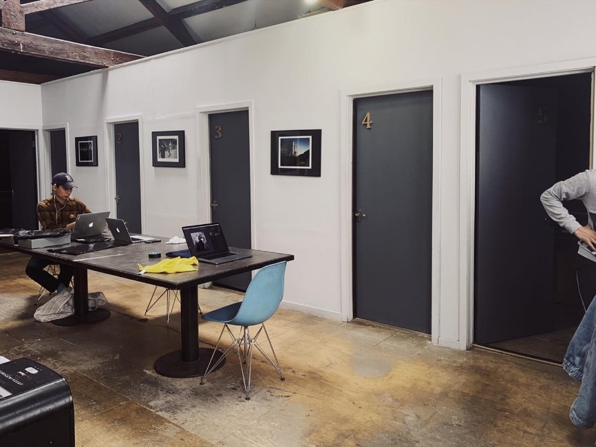 The darkroom corridor at Chan Photo Lab, with numbered darkroom doors and a shared work table